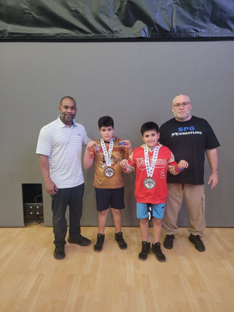 Young wrestlers with state medals and their coaches
